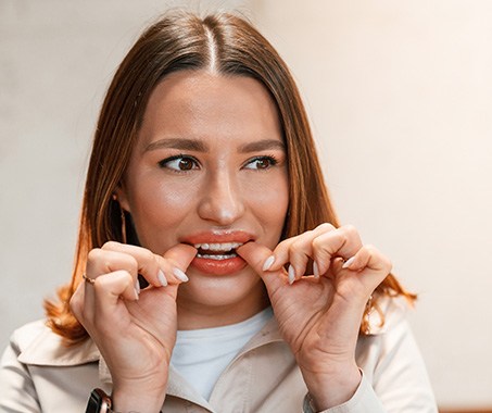 Patient putting on clear aligner in treatment room