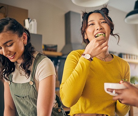 Group of friends enjoying meal together in kitchen