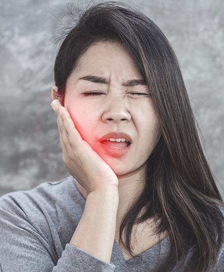 Woman holding the side of her jaw in pain