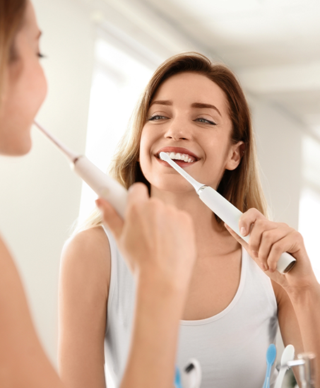 Smiling woman brushing her teeth