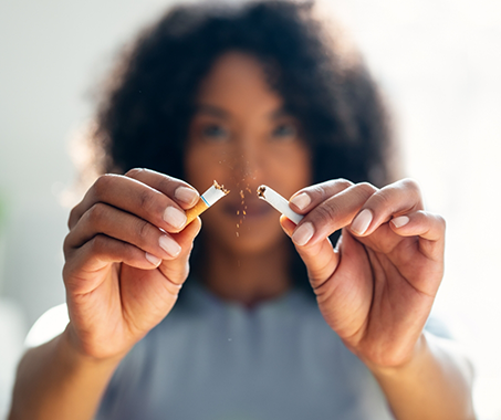 Woman breaking a cigarette in half
