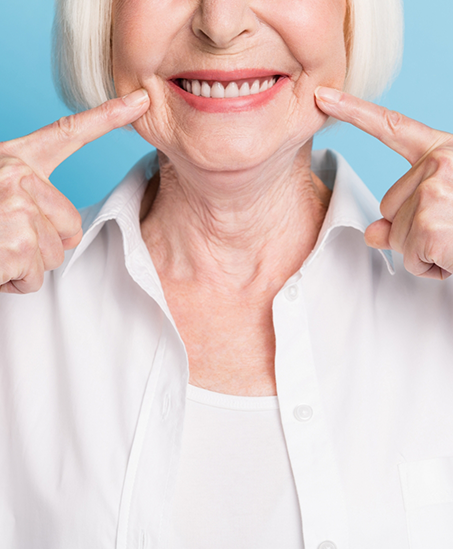 Smiling senior woman pointing to her teeth