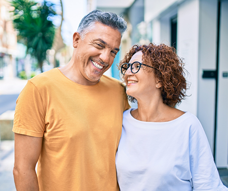 Smiling couple standing on a city sidewalk