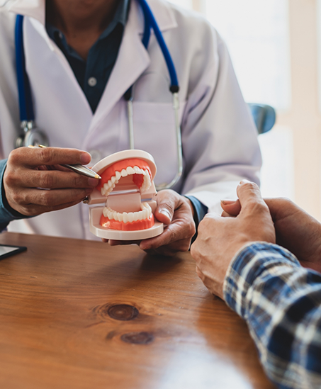 Dentist showing dentures to a patient