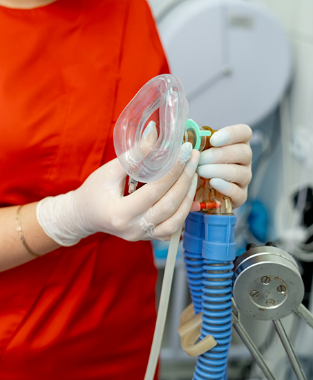 Dental team member holding a nose mask for nitrous oxide