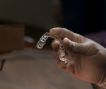 Dentist holding an Invisalign tray