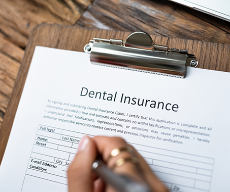 Person filling out dental insurance paperwork
