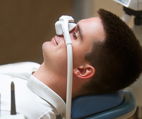 Patient relaxing while breathing in nitrous oxide in treatment chair