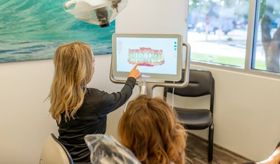 Dental team member showing a patient a scan of their teeth