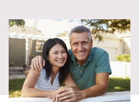 Older couple smiling in their front yard