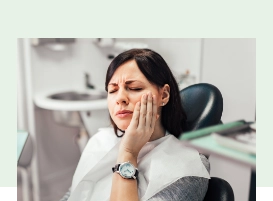Dental patient holding her cheek in pain