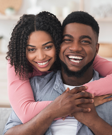 Young man and woman hugging at home