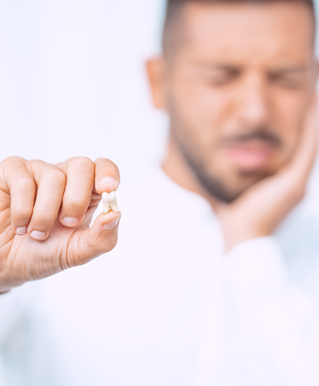 Man holding his extracted tooth
