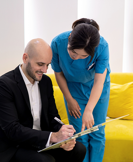 Dental team member helping a man fill out paperwork