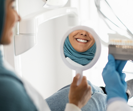 Dental patient seeing her smile in a mirror