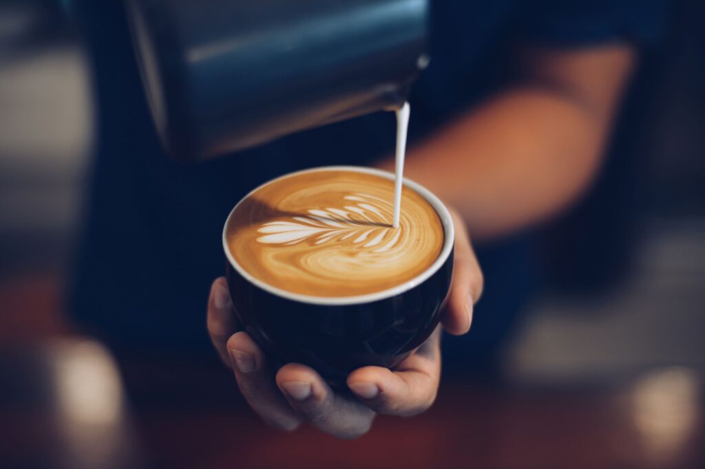 Server pouring cream into coffee