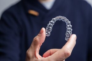 Dentist holding up an Invisalign tray