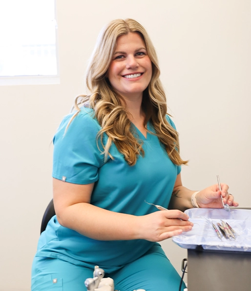Smiling Goodman Dental team member sitting at a desk
