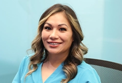 Smiling dental team member in light blue scrubs